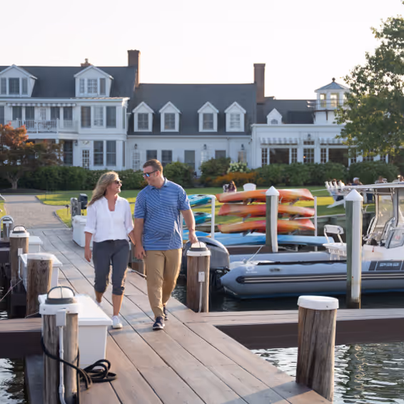 A couple walking on a boat pier.