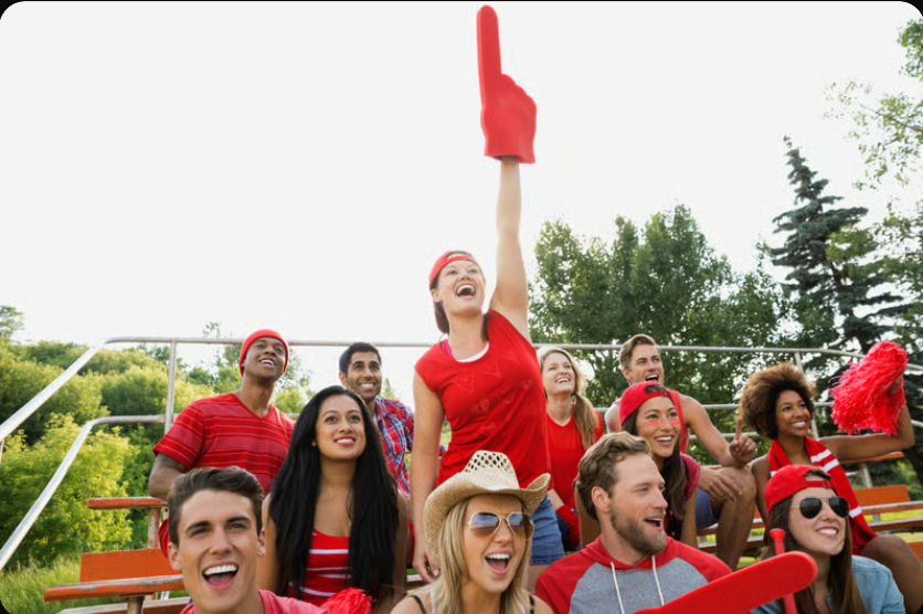 Smiling fans cheering at an outdoor sporting event