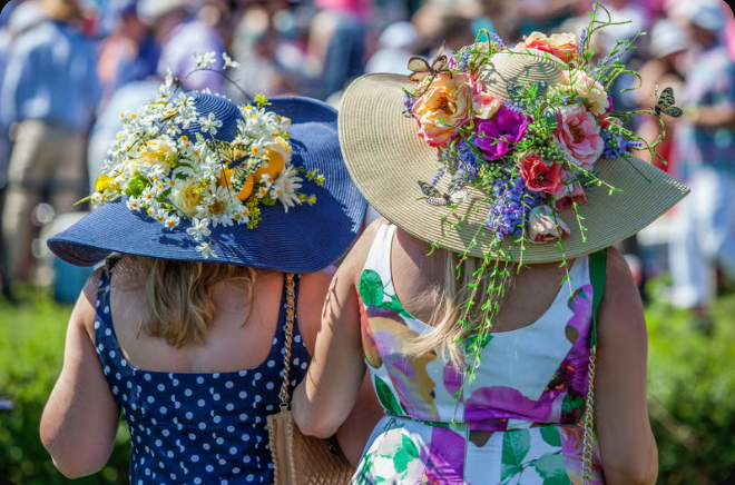 Women in floral hats attending outdoor event