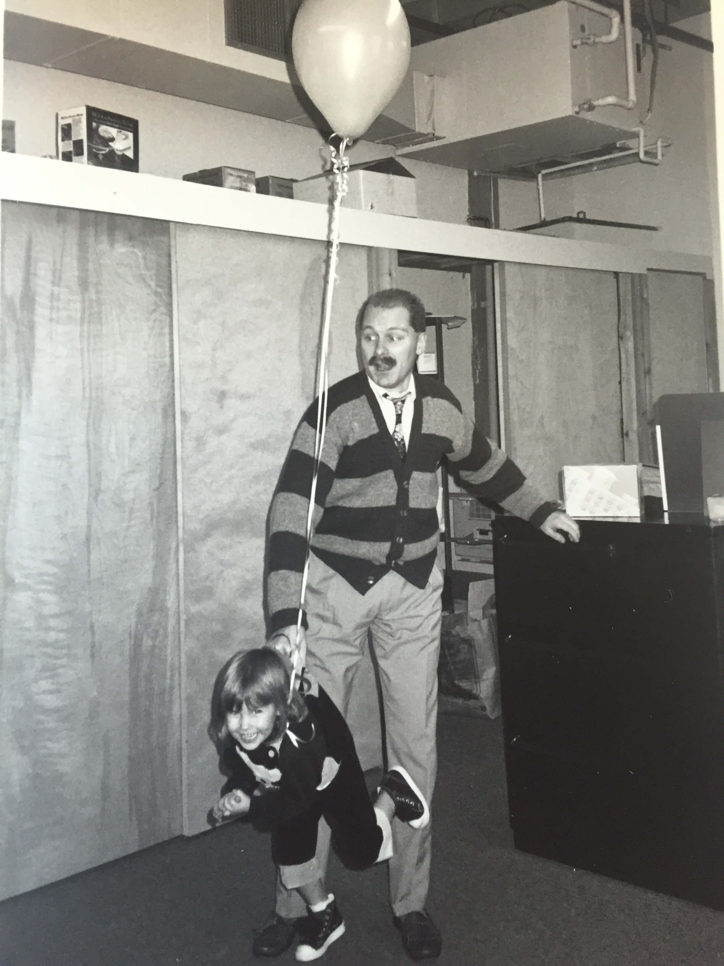 Randy Borns carrying daughter Leah with a balloon