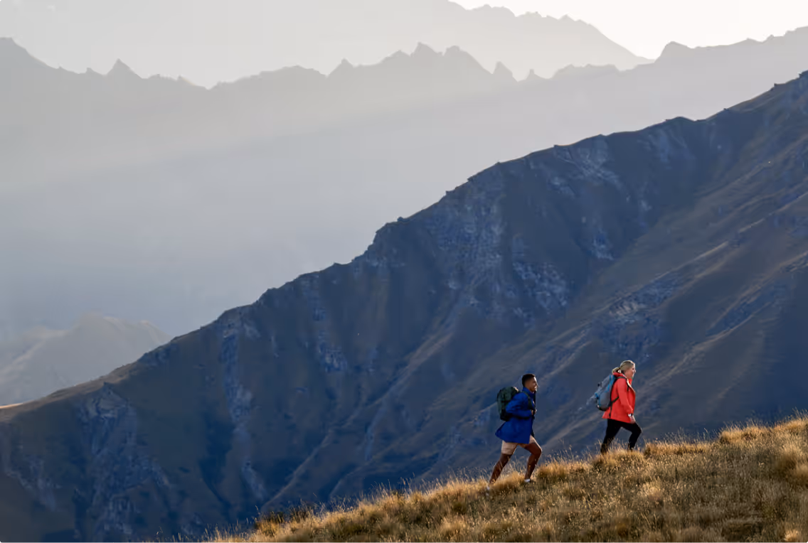 Two people successfully climbing a mountain