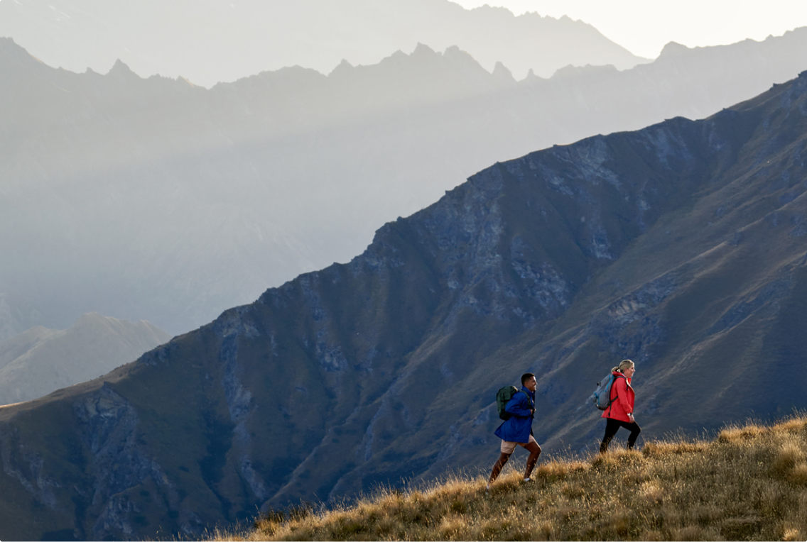 Two people successfully climbing a mountain