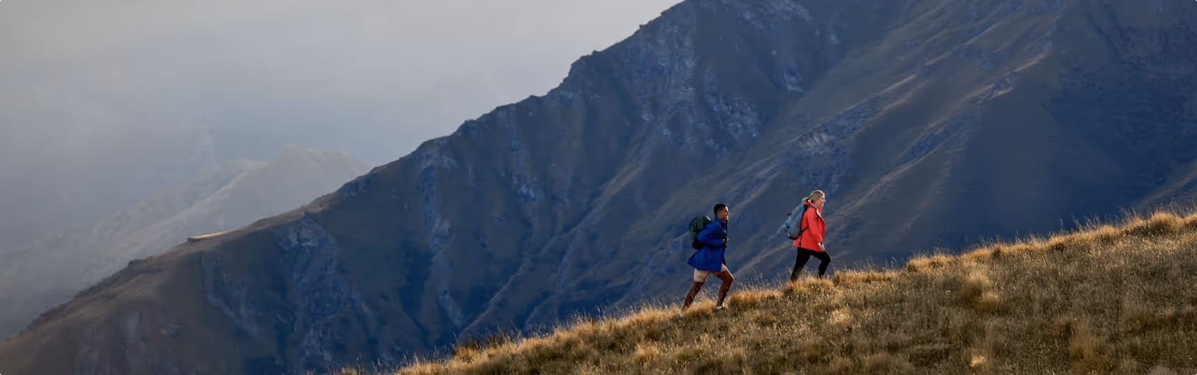 Two people successfully climbing a mountain