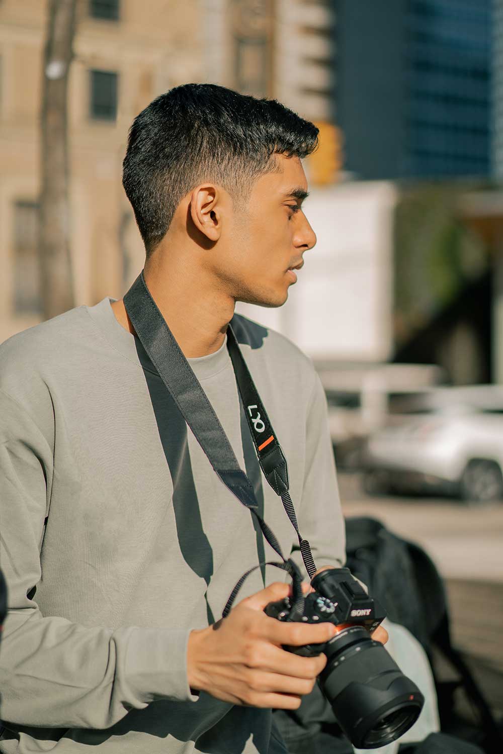 Joshua Chandar holding a camera in the heart of Vancouver.
