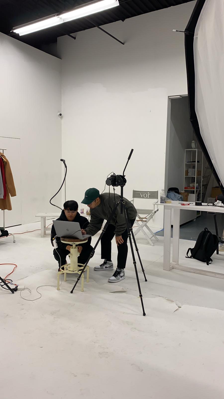 Matthew Subade and coworker collaborating on a laptop in the photography studio.