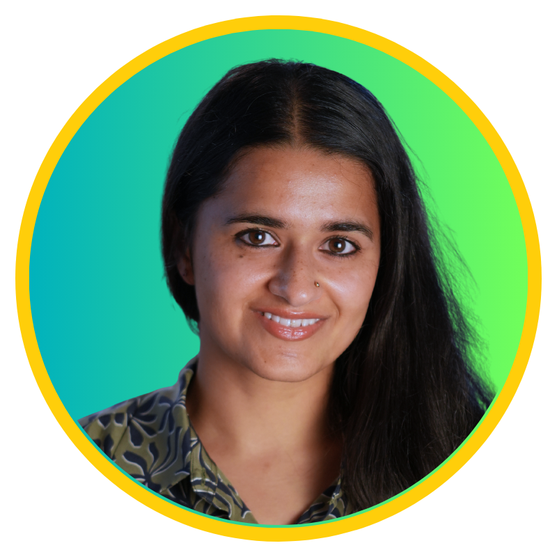 Smiling woman with long dark hair and nose ring wearing a patterned shirt against a teal to green gradient background with a yellow circular border.