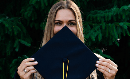 A girl student holding the headgear of toga