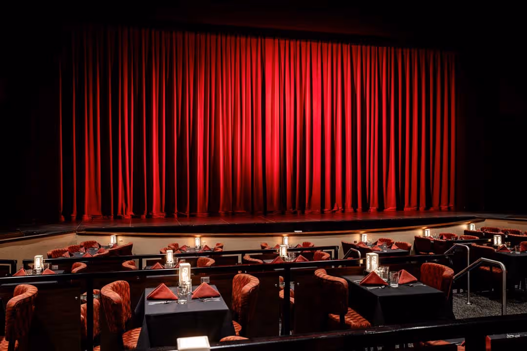 A picture of a community theatre stage with a striking crimson curtain.