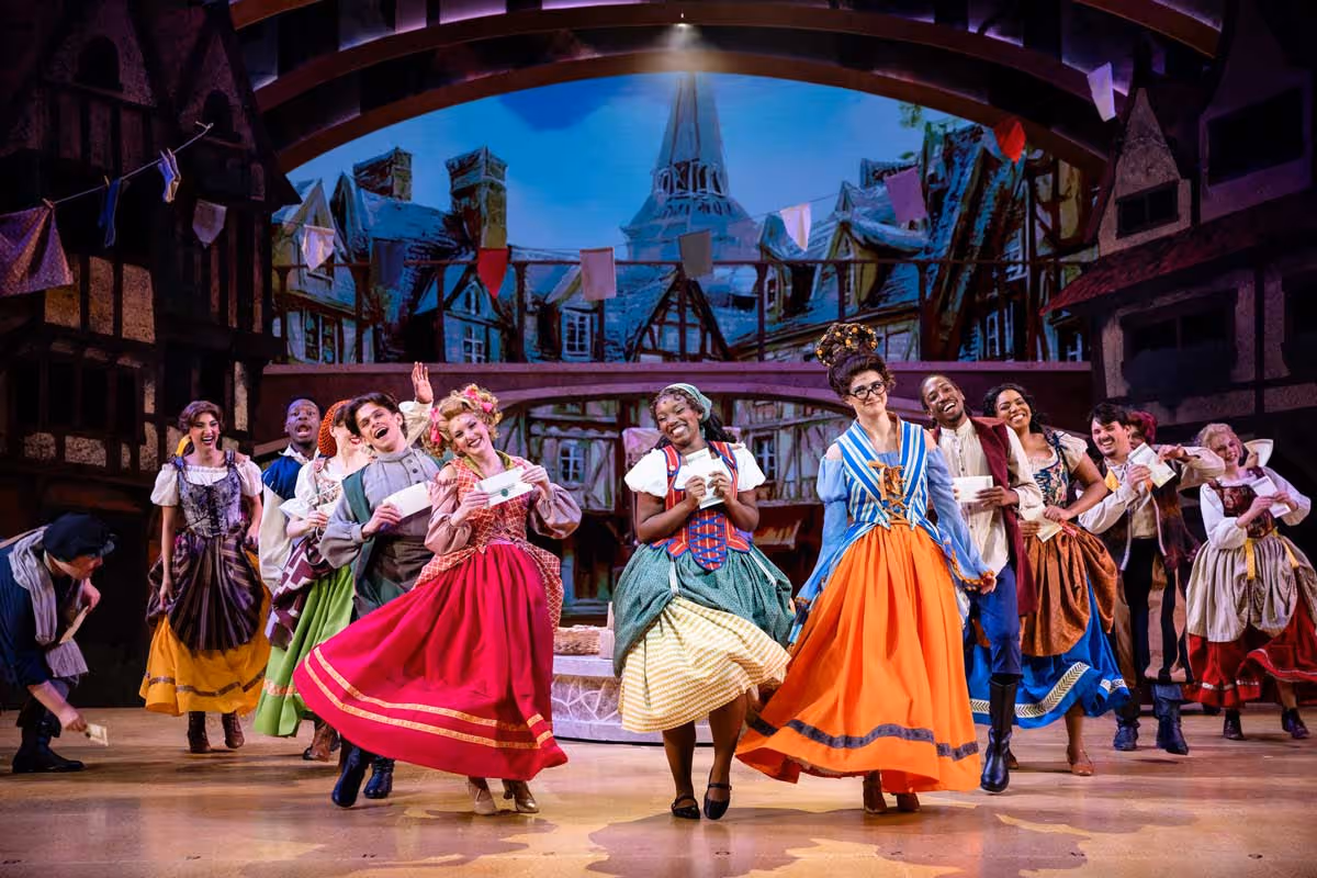 A group of actresses wearing colorful dresses dance while performing "Cinderella."
