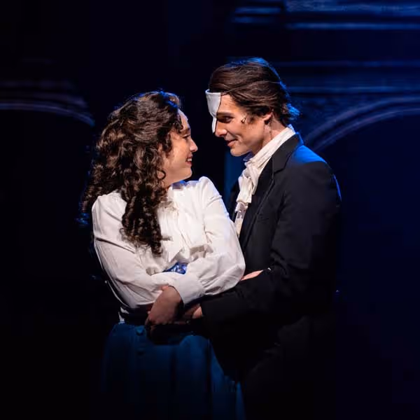 The lead actors from the Phantom of the Opera gaze into each others eyes.