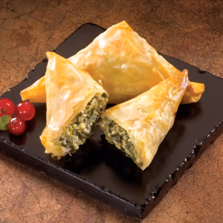 Spanikopita arranged artfully on a plate.