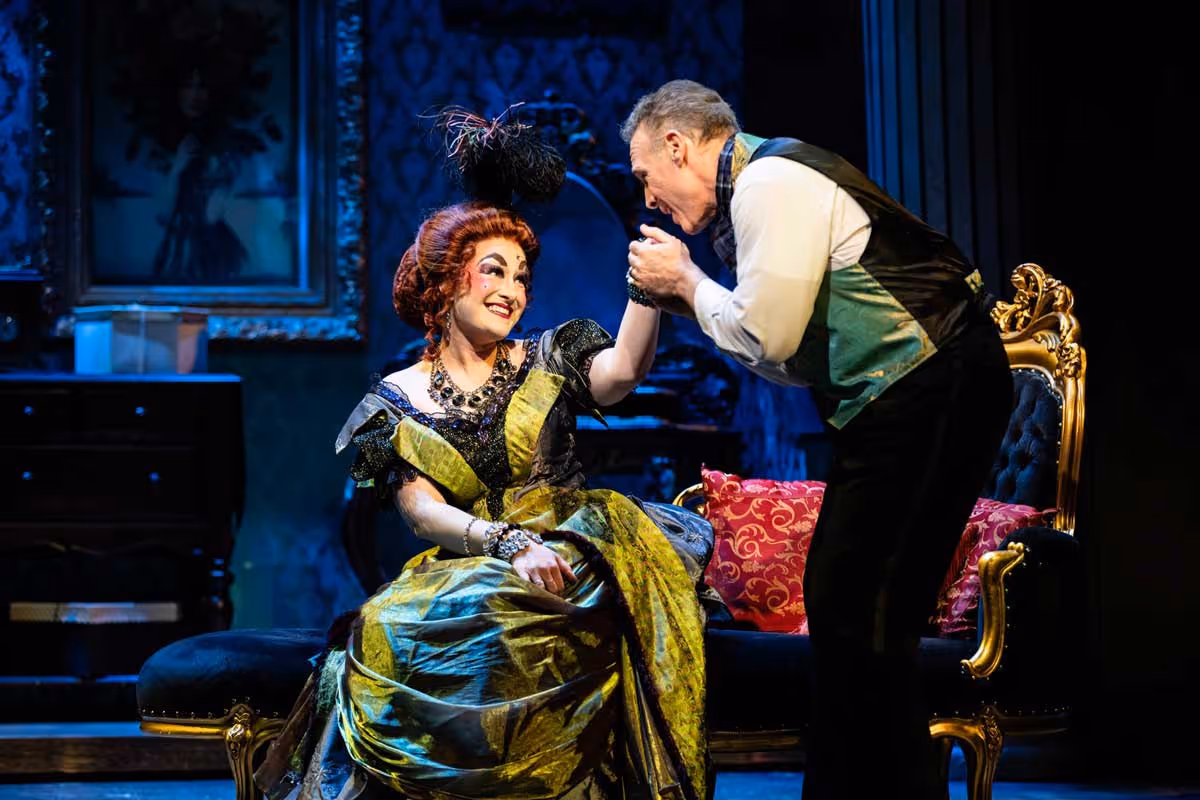 The lead actress of "Hello Dolly" receives a kiss on the hand from a fellow cast member.