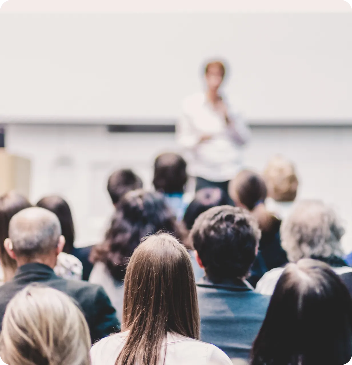 A woman standing in front of a crowd of people.
