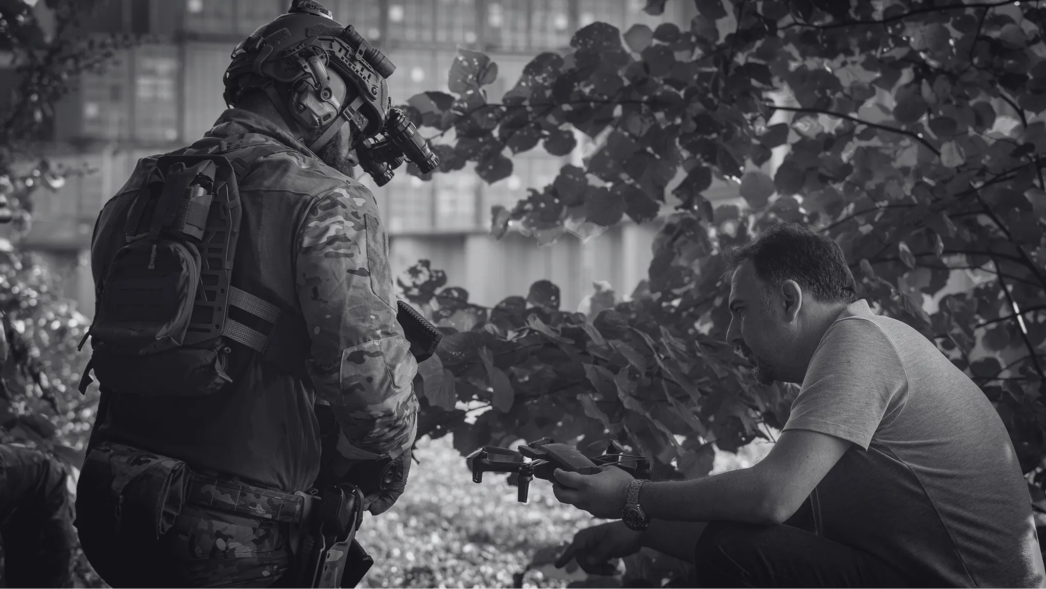 A man kneeling down next to a man in a military uniform.