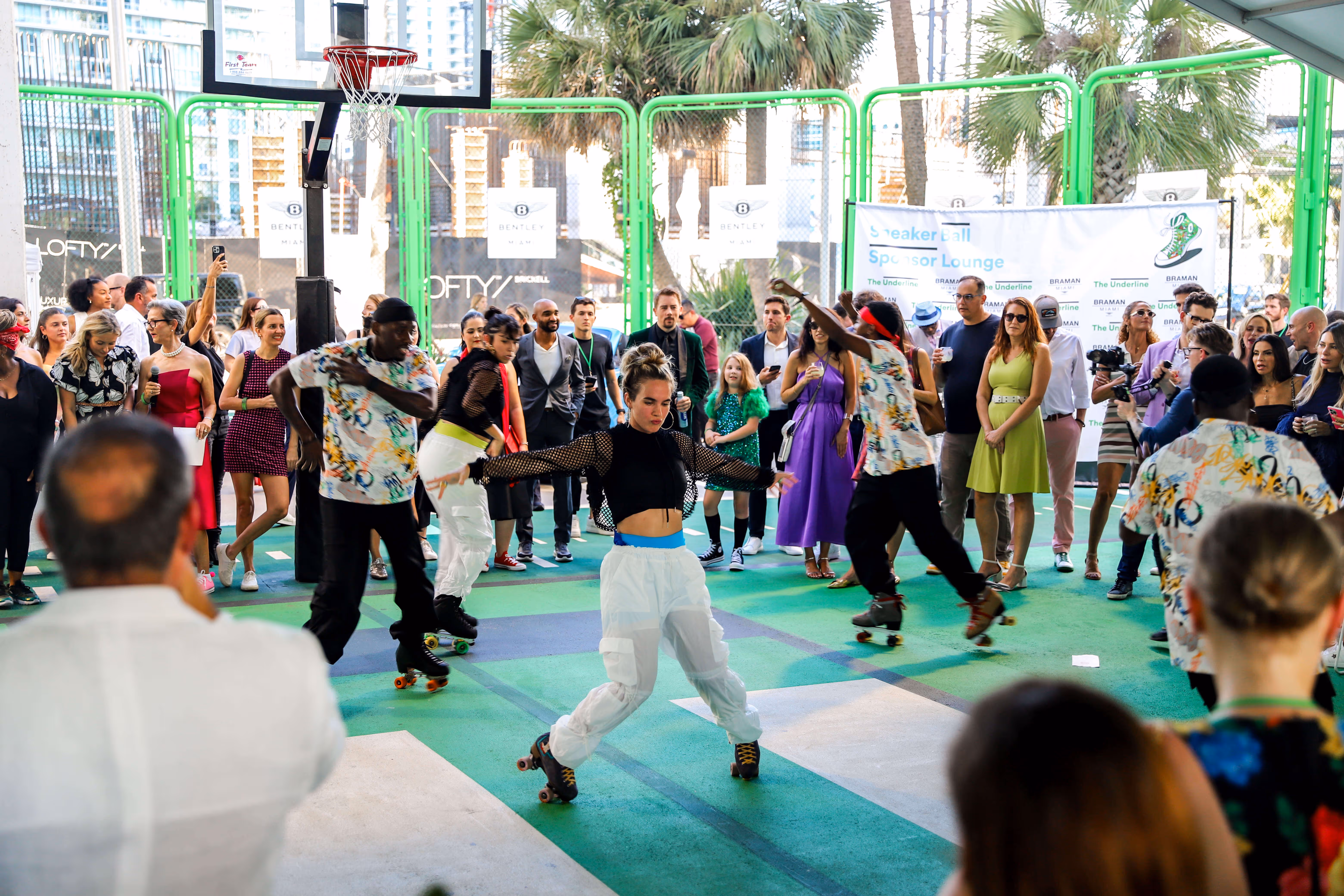 Group of roller skaters performing on a basketball court surrounded by a crowd of spectators.