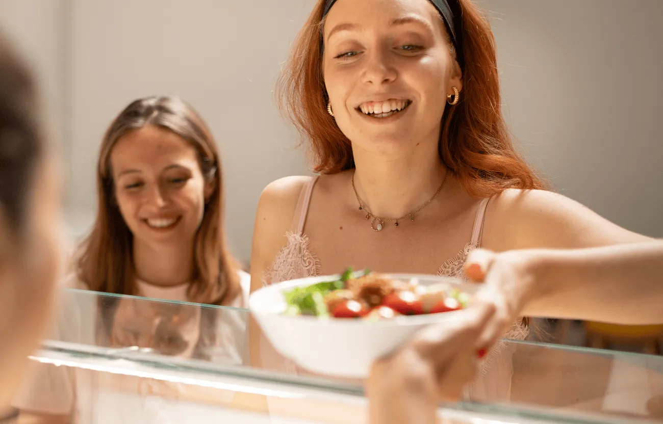 une jeune femme prend une salade à son restaurant d'entreprise