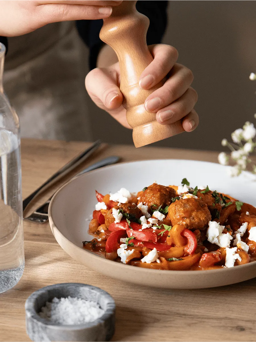 un cuisinier sale une assiette de boulettes de viande avec des poivrons cuisinée par Popchef