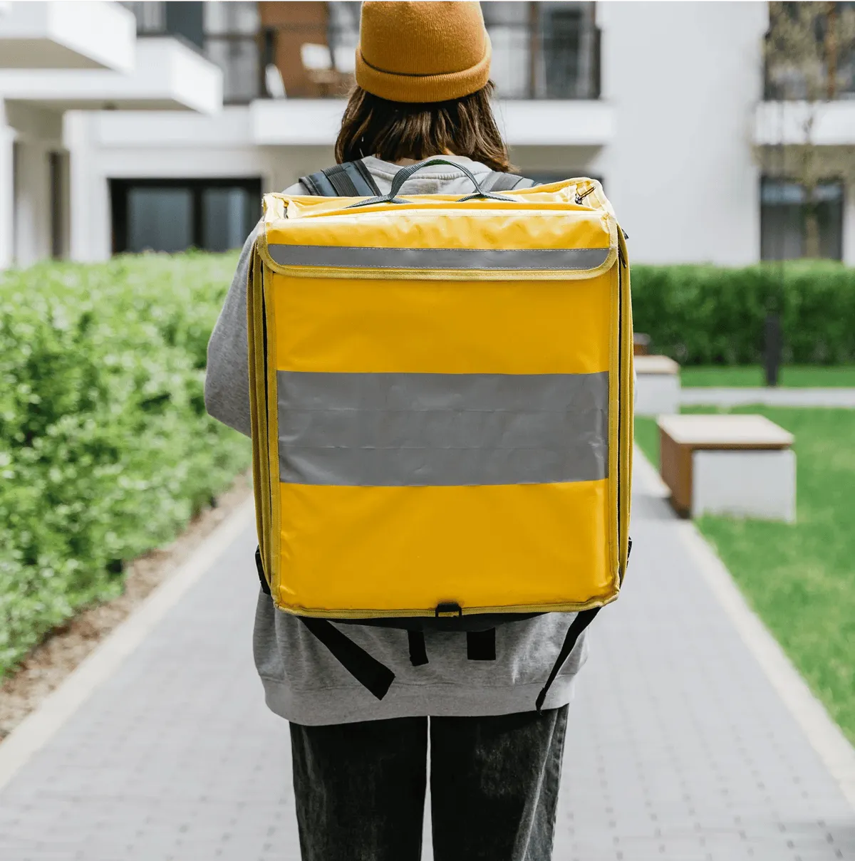 un homme travaillant dans la logistique et portant un sac à dos jaune