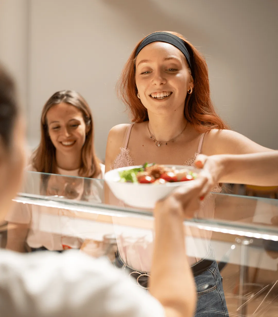 une jeune femme prend une salade à son restaurant d'entreprise
