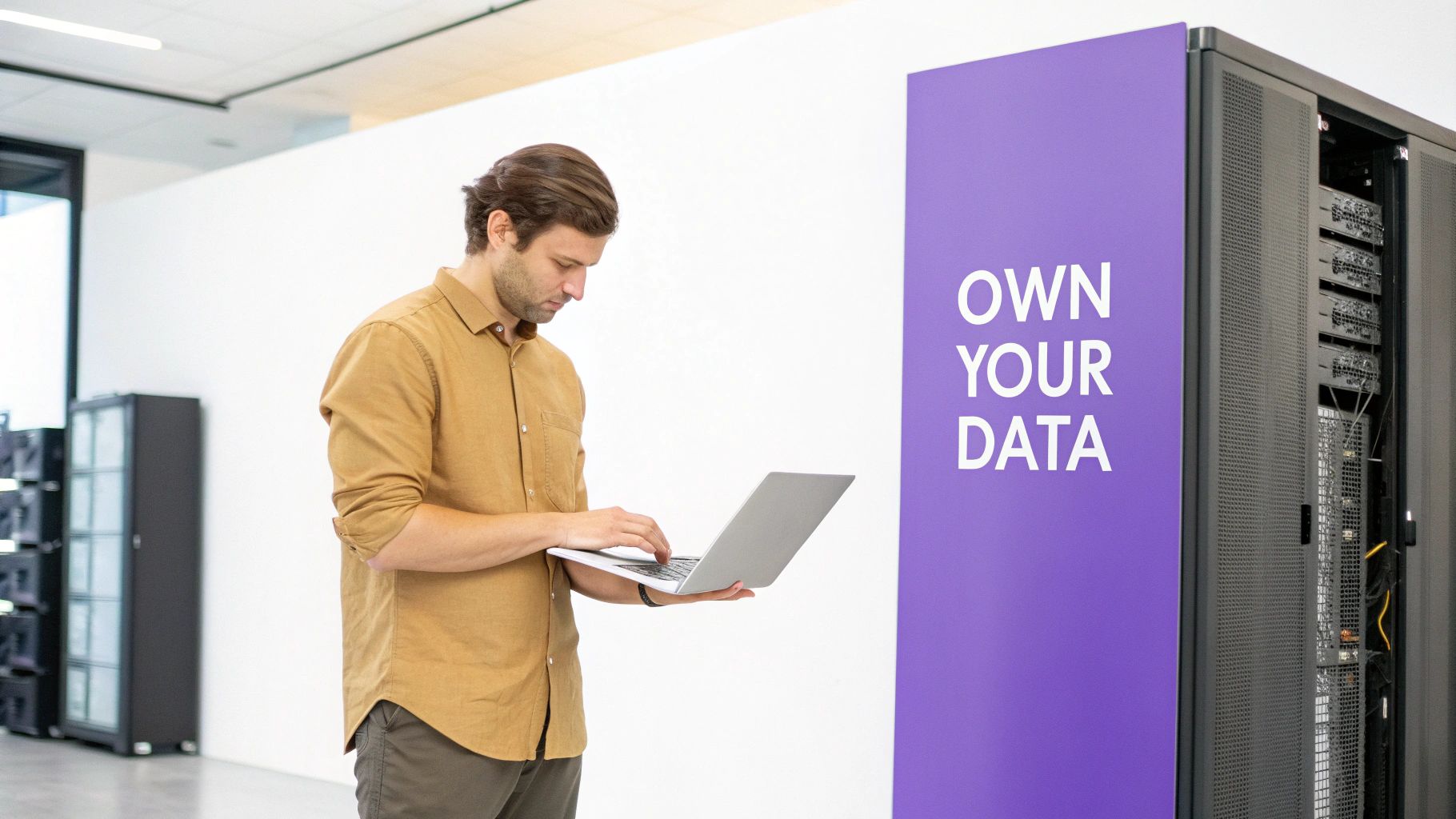 IT professional managing self-hosted server infrastructure with laptop in modern data center