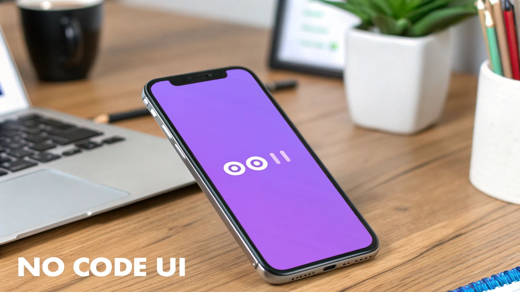 A silver iPhone on a wooden desk displaying a minimalist purple app screen, next to a laptop.