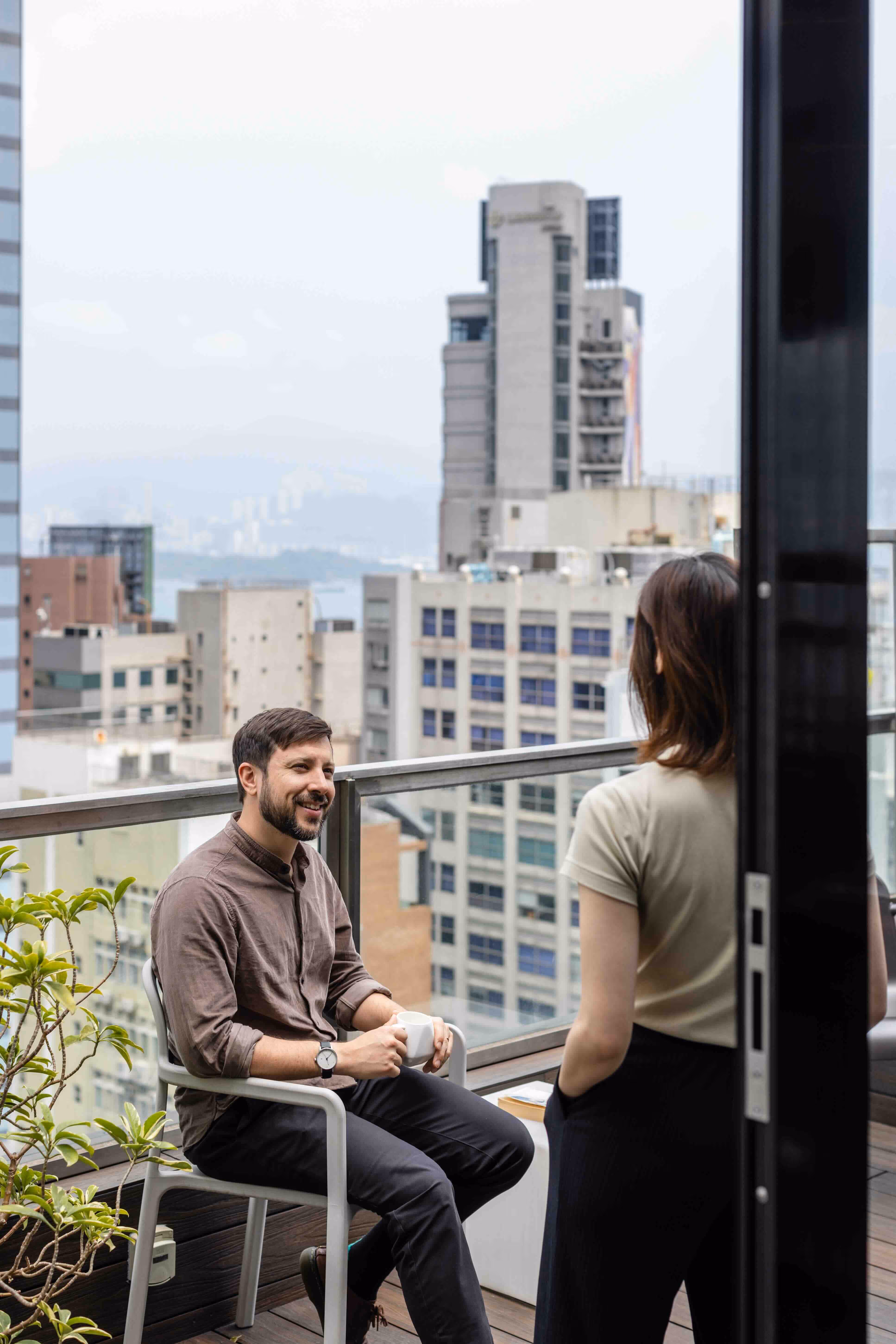 man sits on terrace drinking coffee at coworkspace