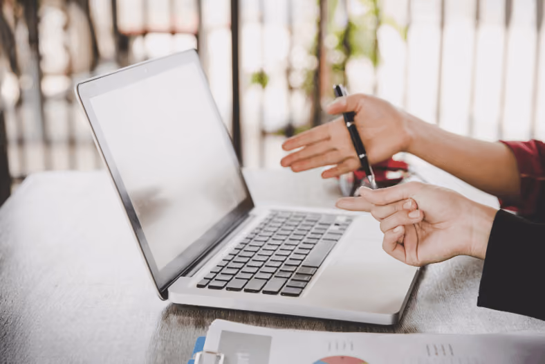 Businesswomen analyzing documents on laptop on office desk close up