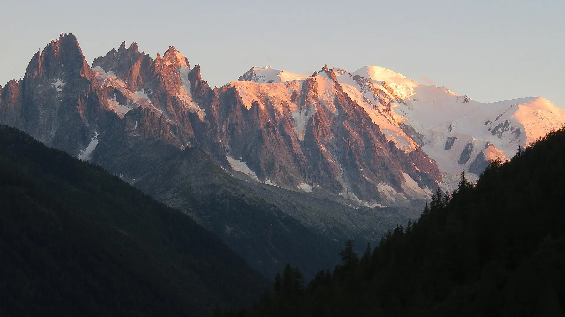 Une montagne enneigé avec un coucher de soleil