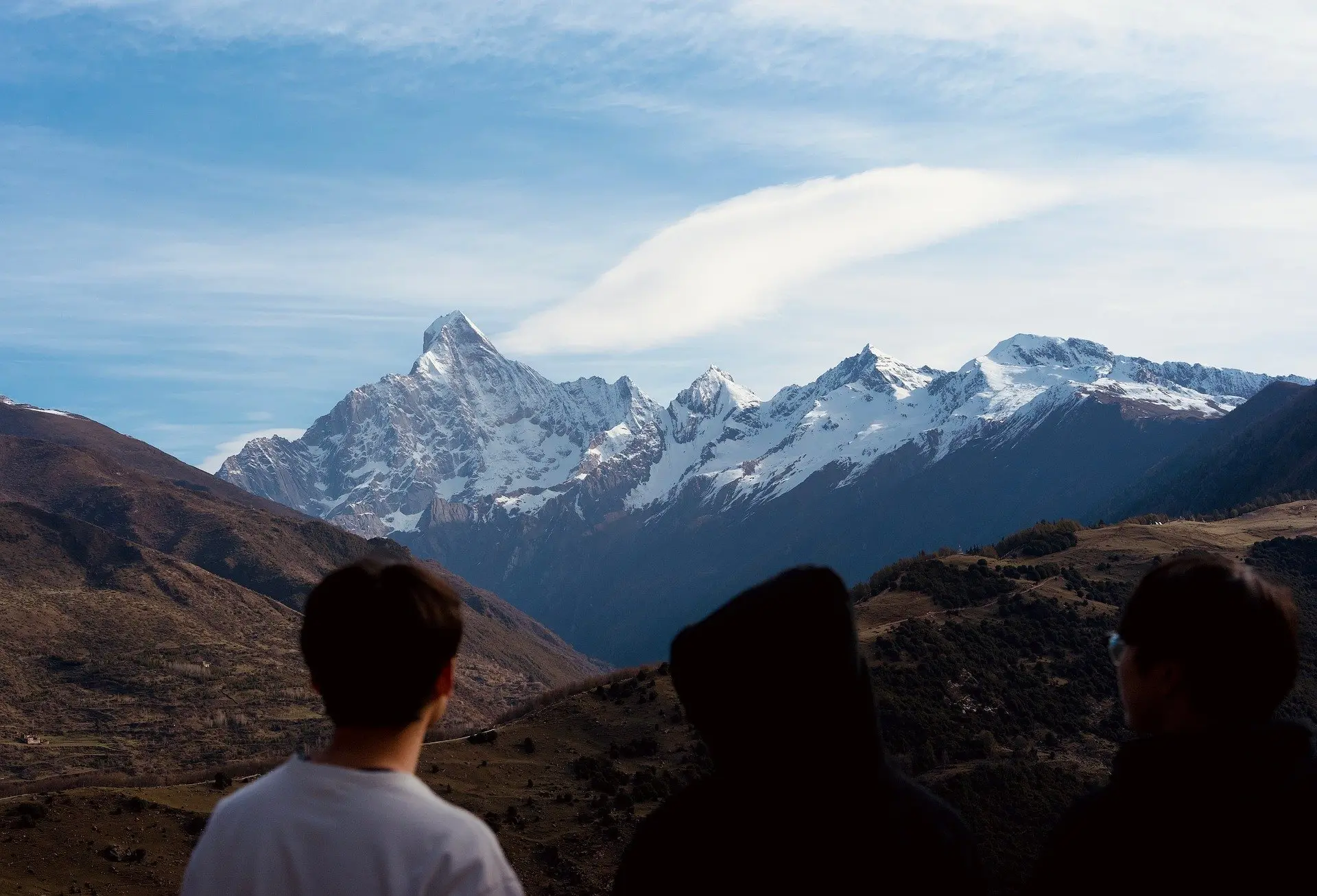 Des jeunes gens regardent des montagnes au loin