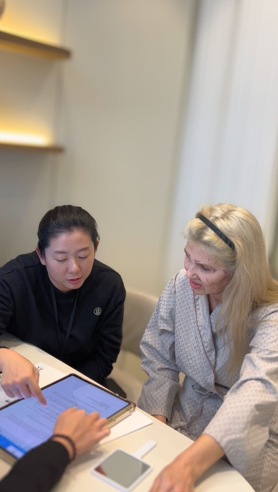 Beauty Hopper coordinator going through a treatment plan on a tablet with a patient