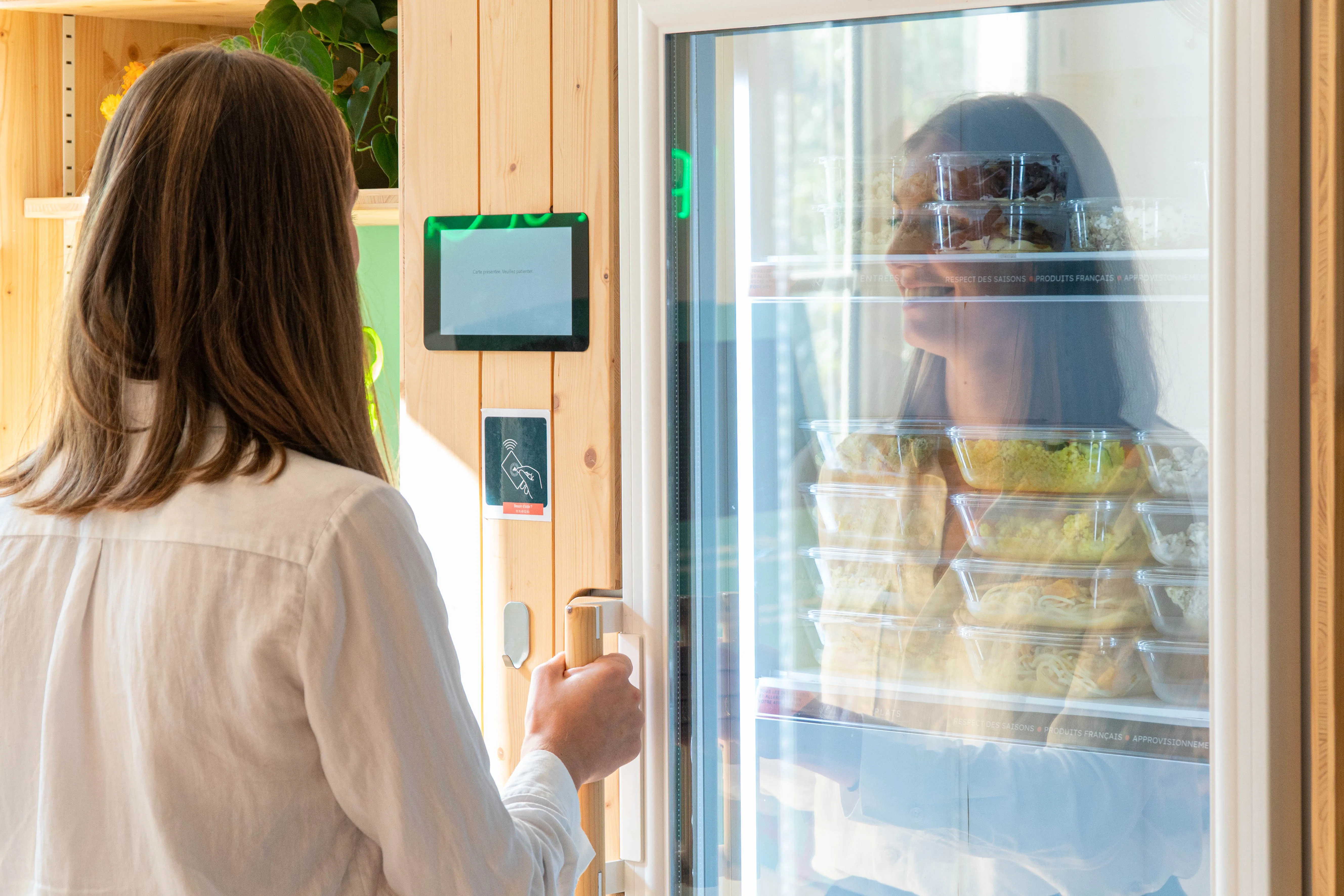 une femme qui s'apprête à ouvrir le frigo d'entreprise Popchef 