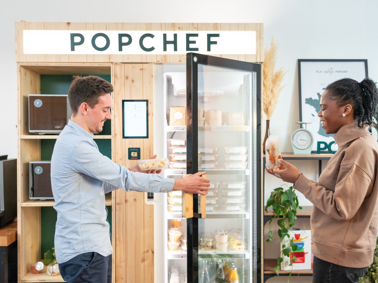 Deux personnes ouvrant un frigo connecté