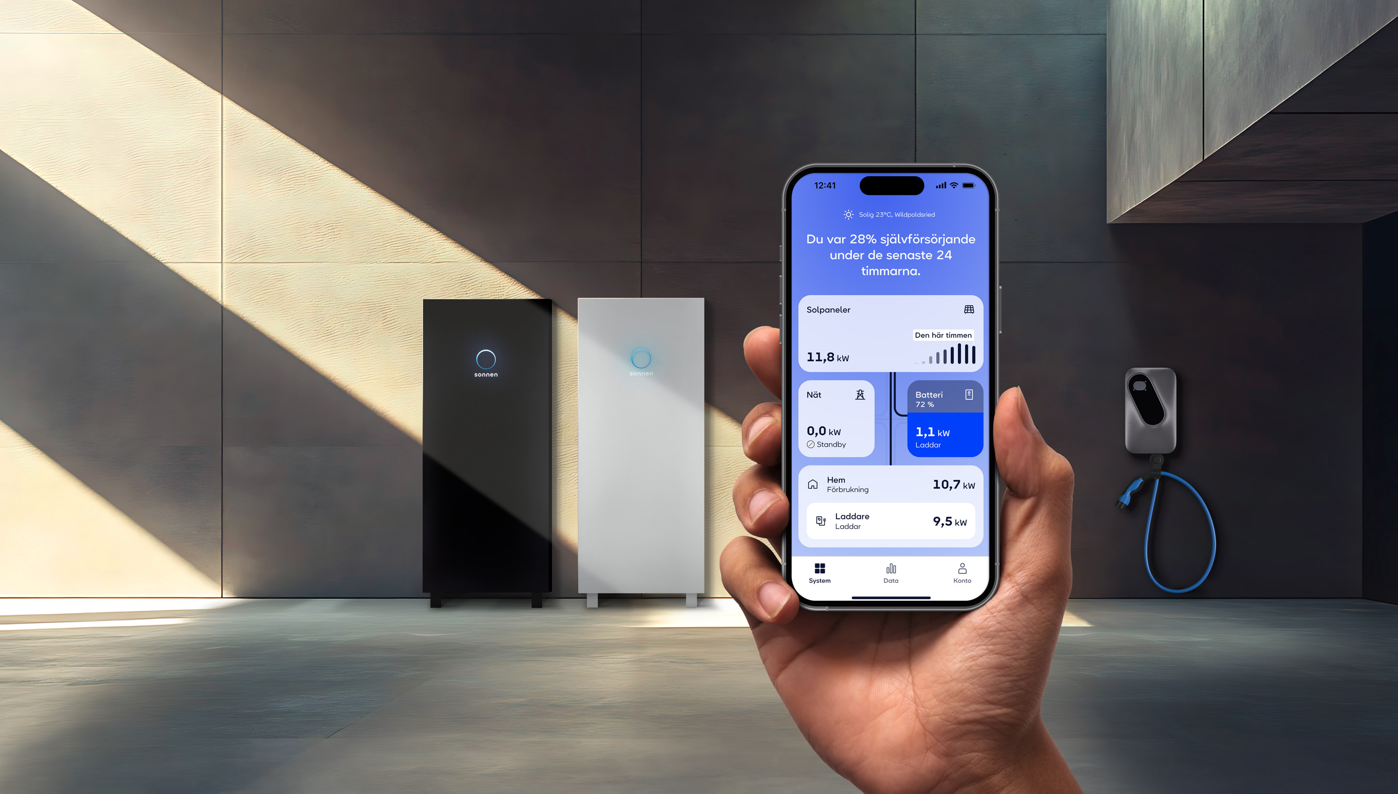 En hand håller en smartphone med sonnen-appen framför sonnen-batterier och laddare.