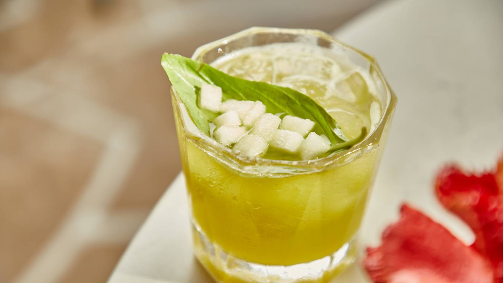 Mojito cocktail with lime, mint, ice cubes, and clear liquid in a glass