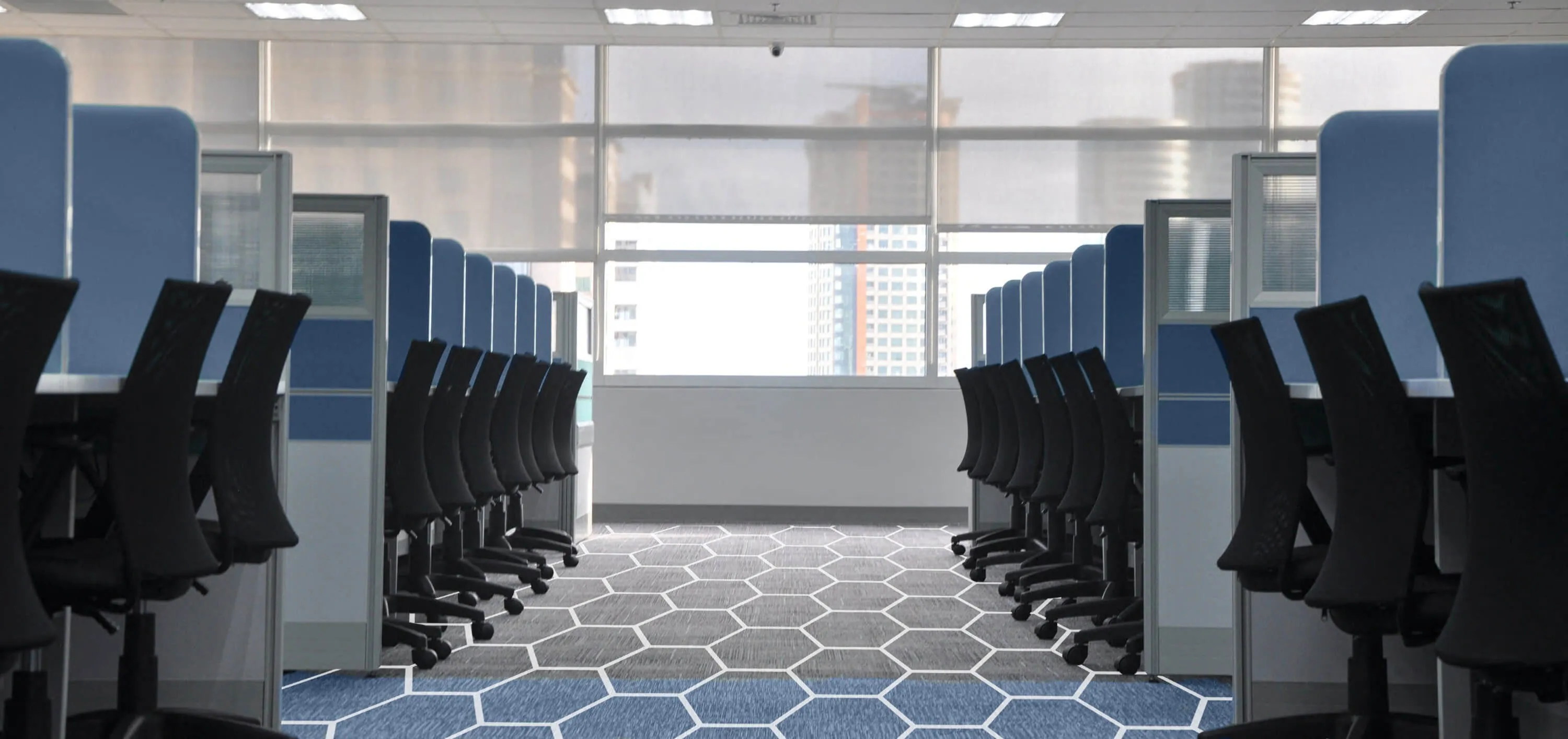 Empty open-plan office with rows of desks and chairs