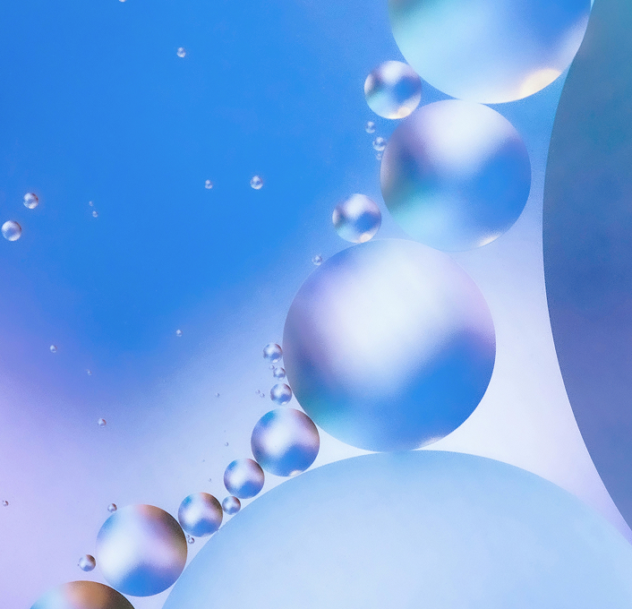 Abstract visual of oil droplets in soft blue and purple tones, used as a key visual in Simplyfined’s branding to represent transformation and innovation.