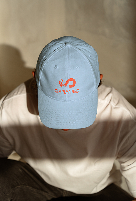 Light blue Simplyfined cap featuring the logo embroidered in red, representing a casual lifestyle application of the brand.