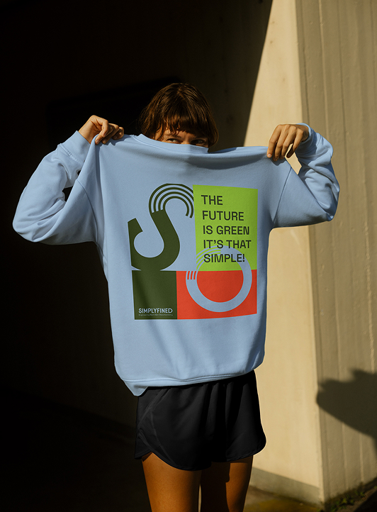 Front view of a person wearing a Simplyfined sweater with the logo and the tagline “The Future is Green. It’s That Simple.”