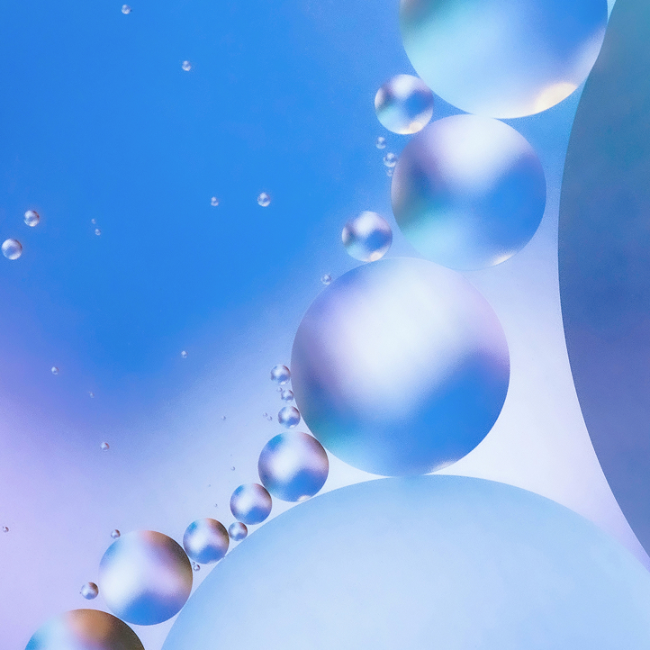 Abstract visual of oil droplets in soft blue and purple tones, used as a key visual in Simplyfined’s branding to represent transformation and innovation.