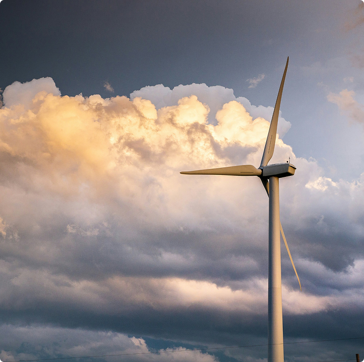Eine Windkraftanlage steht hoch vor einem dramatischen bewölkten Himmel bei Sonnenuntergang und symbolisiert erneuerbare Energien und Nachhaltigkeit.