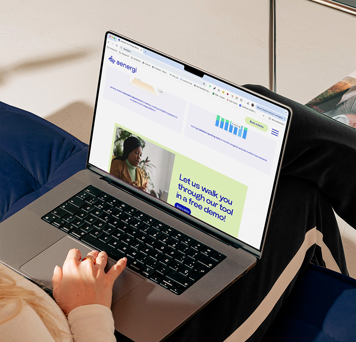 Eine Person, die einen Laptop benutzt, auf dem die Aenergi Website mit der Überschrift „Lass uns dir das in einer kostenlosen Demo erklären!“ zeigt. , was die Barrierefreiheit der Plattform hervorhebt.