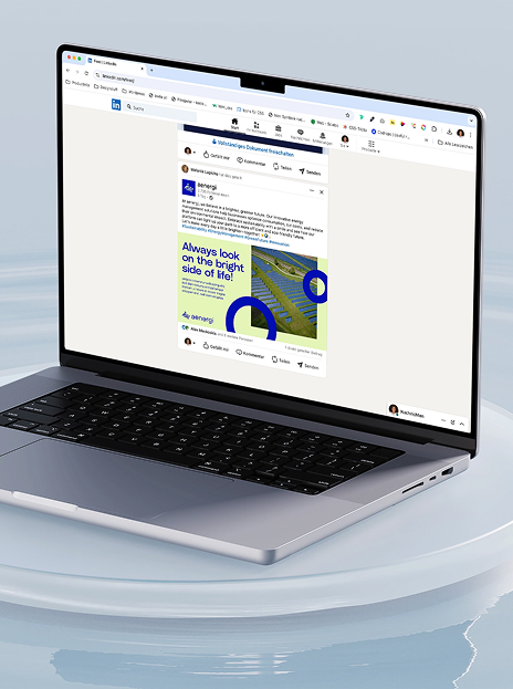 Öffnen Sie den Laptop, auf dem ein LinkedIn-Beitrag von aenergi angezeigt wird, auf dem eine Grafik mit blauen und grünen Formen und dem Text „Always look on the bright side of life!“ zu sehen ist.