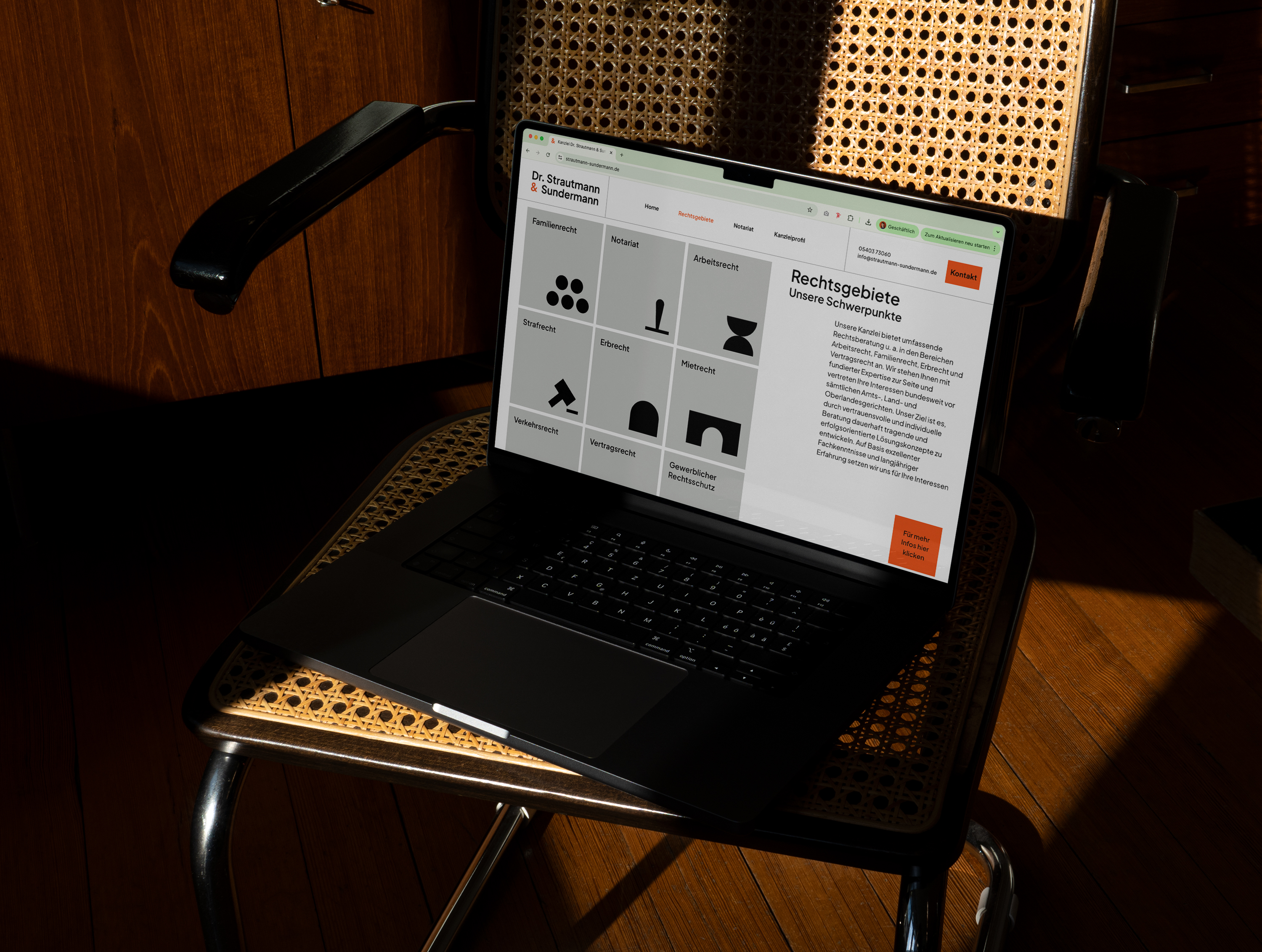 Laptop auf einem Holzstuhl mit der Website der Anwaltskanzlei Dr. Strautmann & Sundermann. Die Seite zeigt verschiedene Bereiche der Rechtspraxis, die mit fetten schwarzen Symbolen dargestellt sind, sowie einen Textabschnitt mit dem Titel „Rechtsgebiete — Unsere Schwerpunkte“.