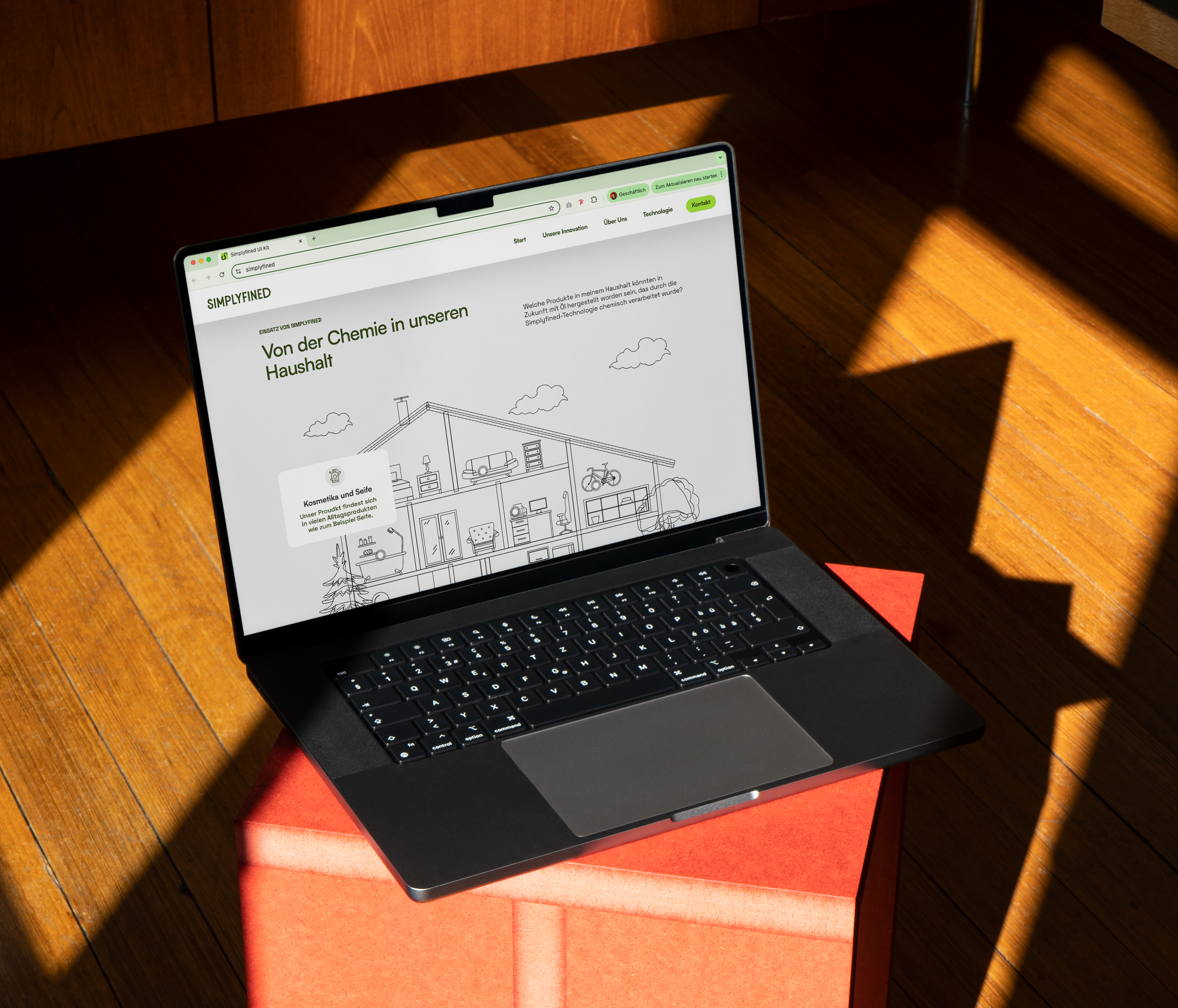 Laptop showing the Simplyfined's landing page with an illustrated house graphic, highlighting everyday household products connected to the start-up’s innovative plant-based oil technology.