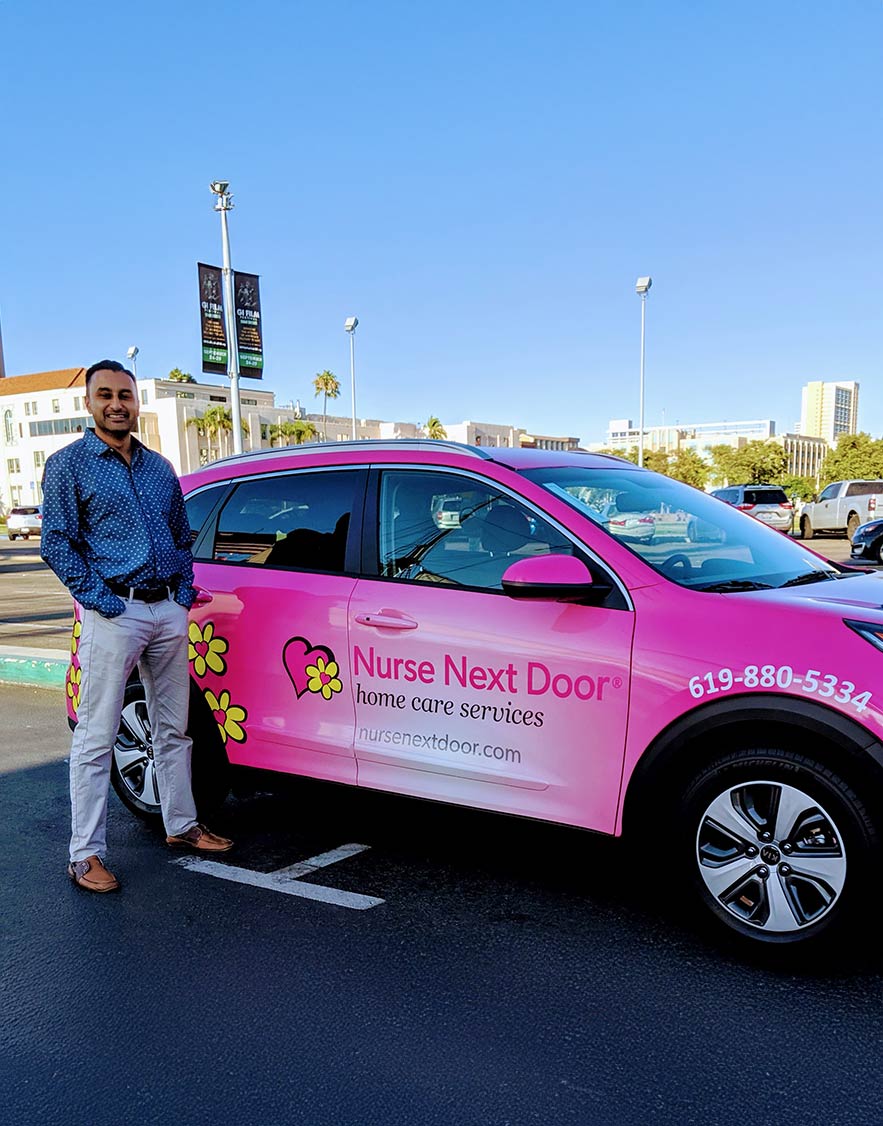 nurse next door franchisee in front of their car.