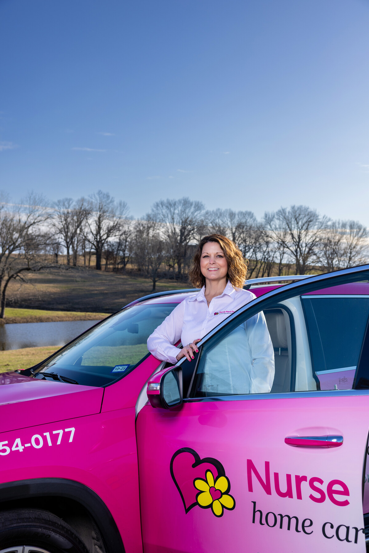 nurse next door franchise in USA standing outside her car.
