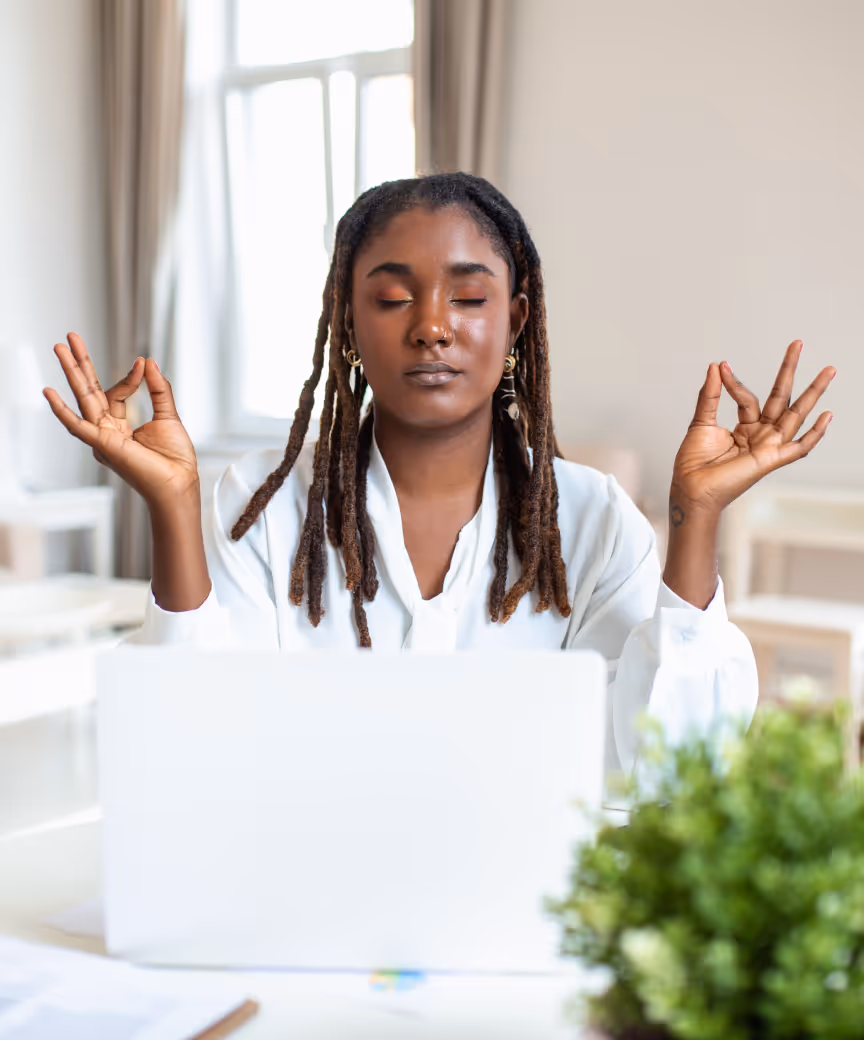 Young professional lady with inner peace sitting behind her laptop at home.