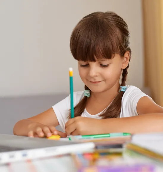 Young child concentrating while doing math for kids exercises on paper.