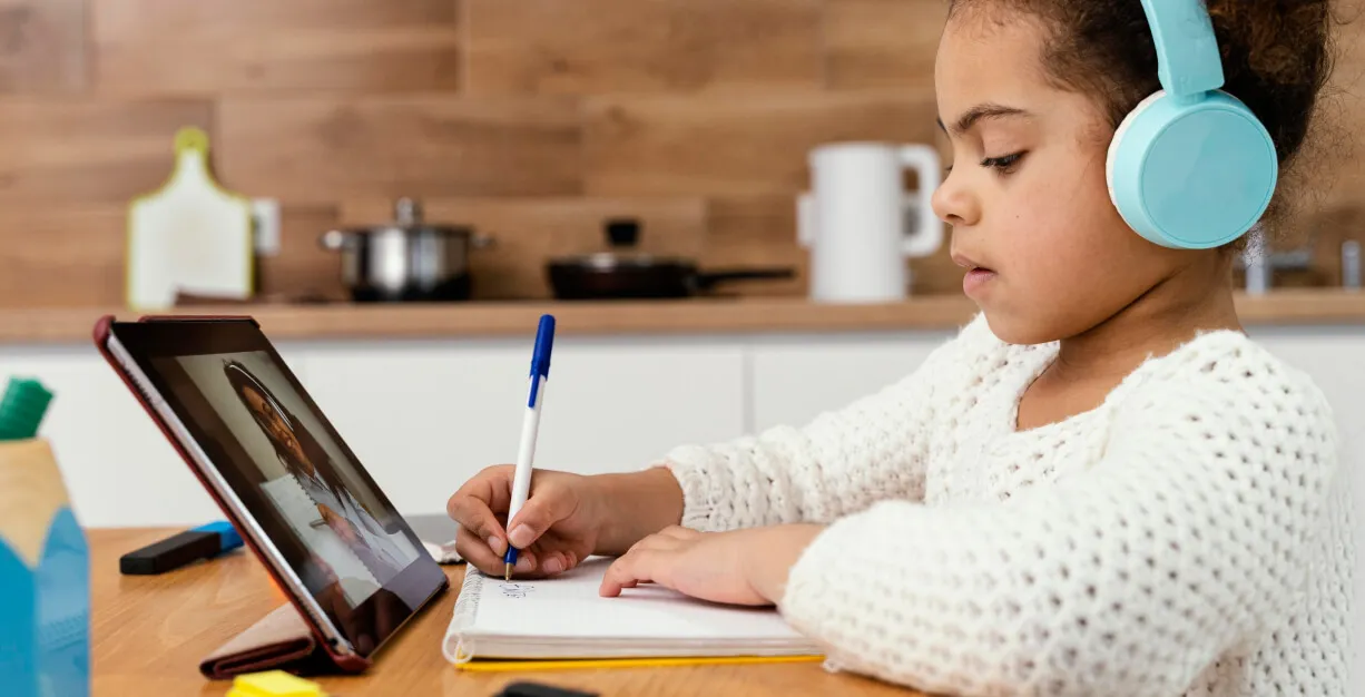 Young child concentrating while doing math online on a one on one class.