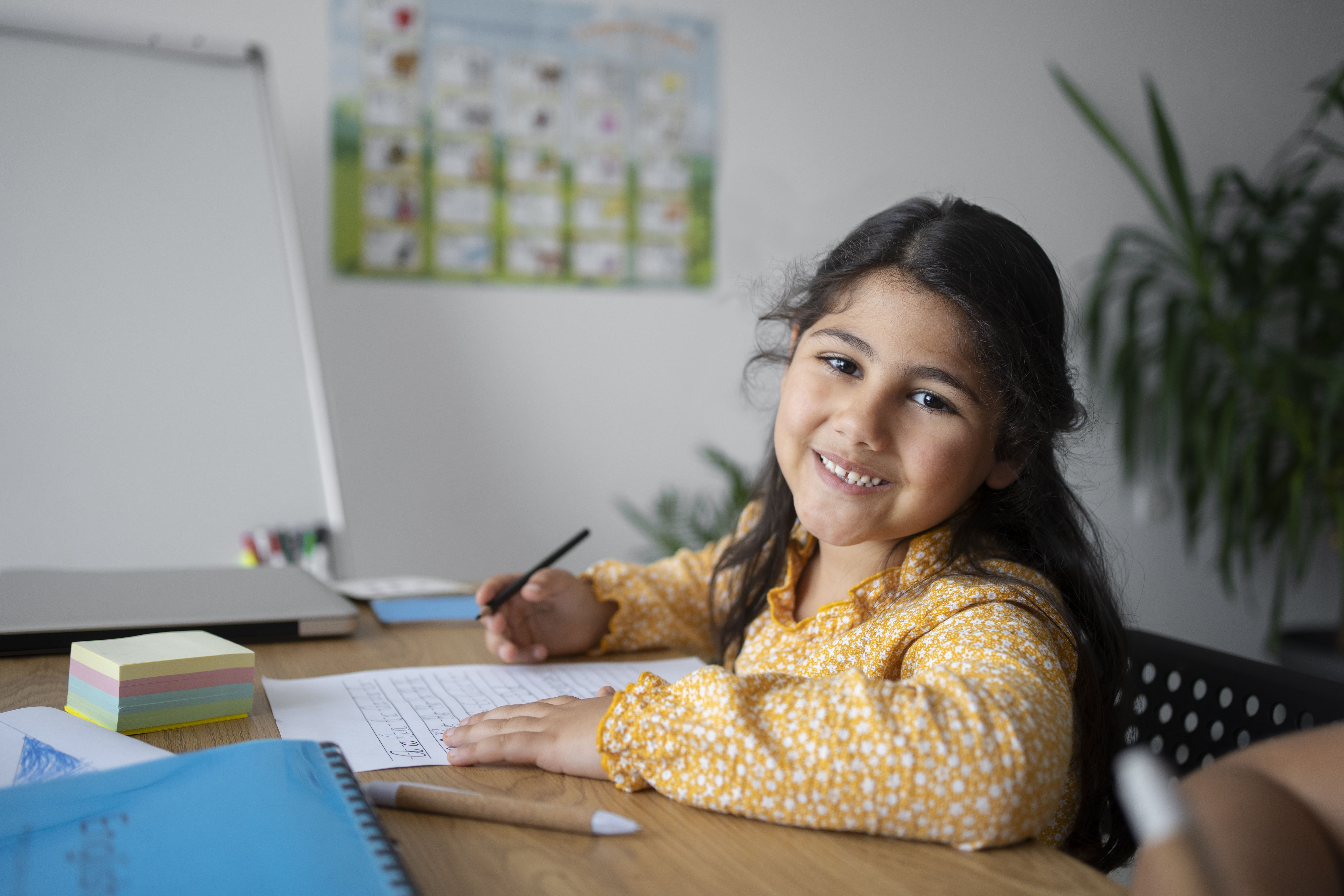 Young child concentrating while doing math for kids exercises on paper.